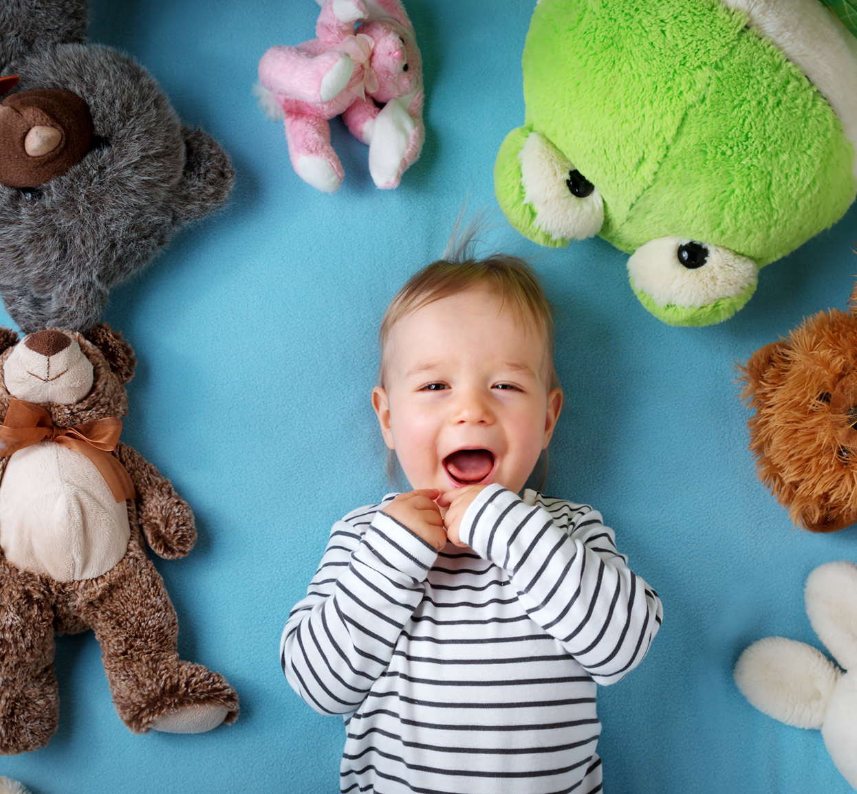 image of pediatric patient surrounded by stuffed animals